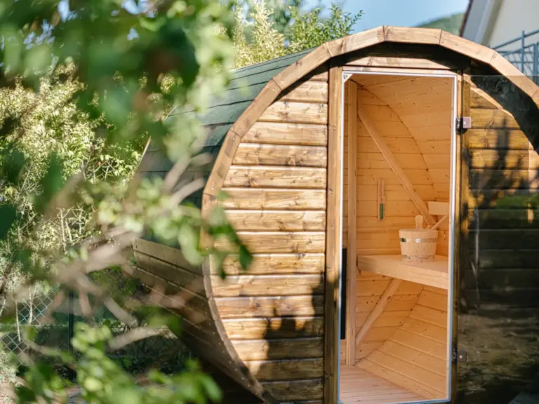 Outdoor Finnish sauna at the Stay Eden MOONSTONE apartment in Ramstein, placed in the garden area with wooden exterior.