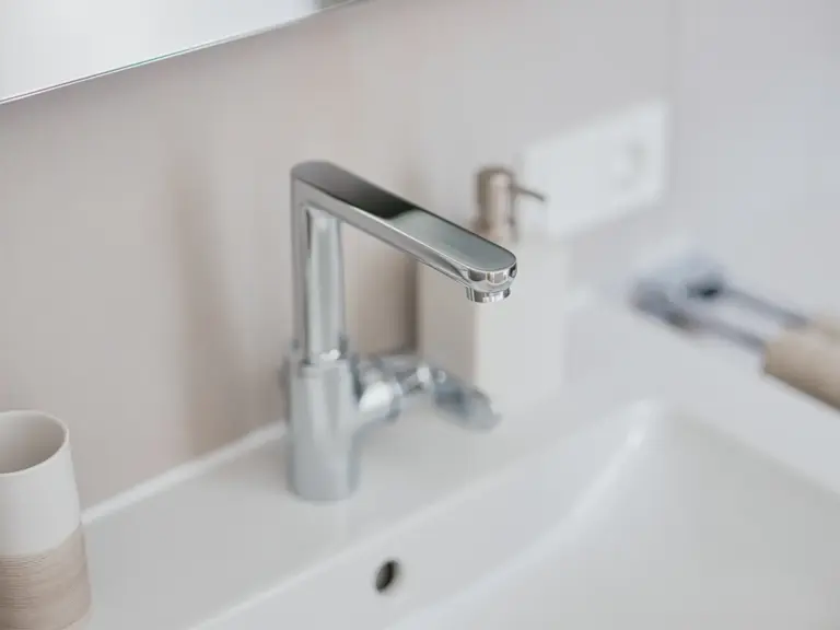 Close-up of modern bathroom faucet in OPAL GREEN apartment