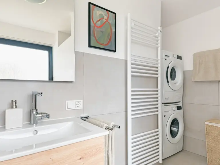 Bathroom with sink, towel radiator and washer dryer in OPAL GREEN apartment