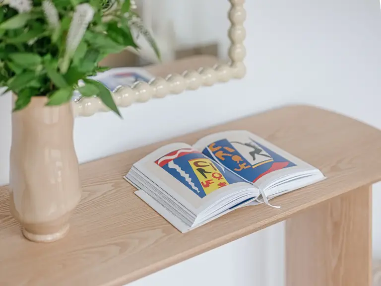 Decorative book on wooden console table in OPAL GREEN apartment