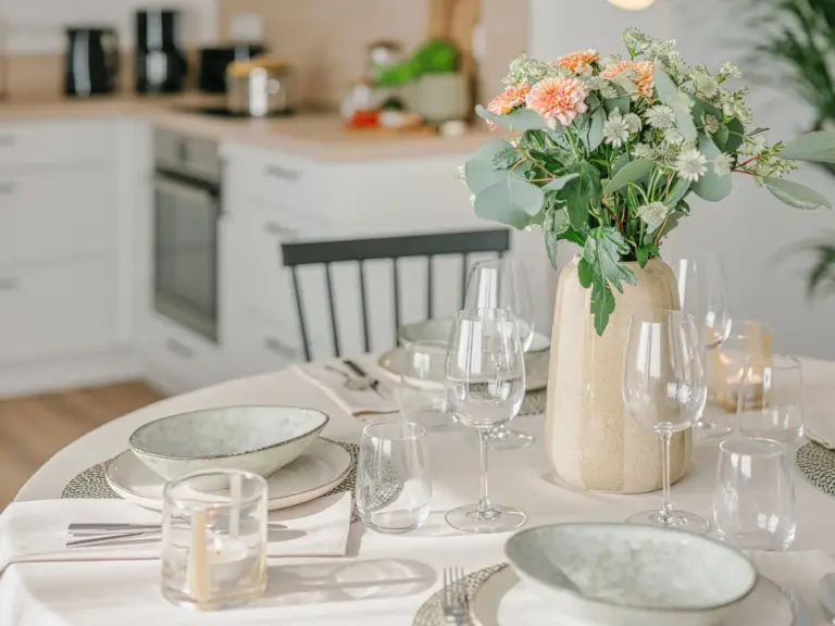 Detail of dining table setting in OPAL BLUE TDY and TLA apartment with kitchen in background