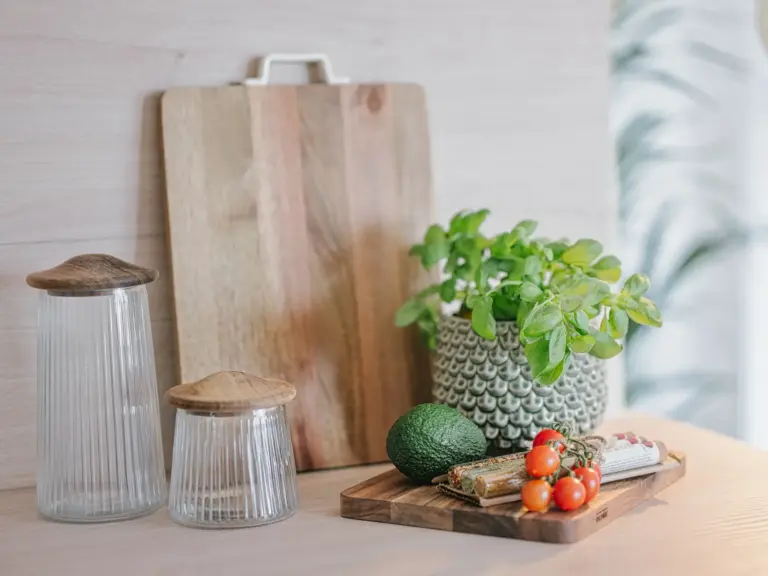 Kitchen counter detail with cutting board, basil plant, avocado and tomatoes in OPAL BLUE apartment