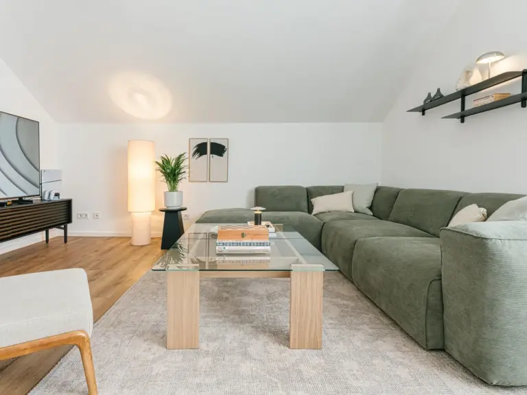 Living room with sectional sofa and TV area in OPAL BLUE TDY and TLA apartment