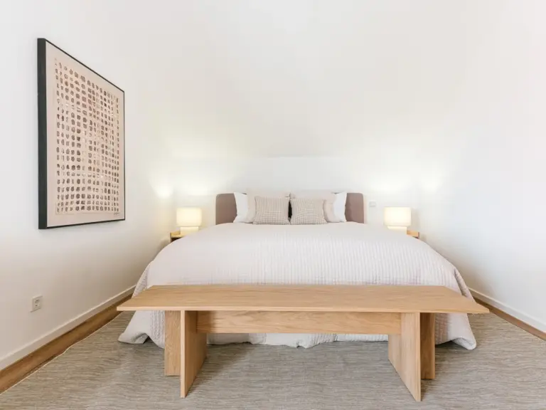 King-size bed with bedside lamps in master bedroom of OPAL BLUE TLA apartment