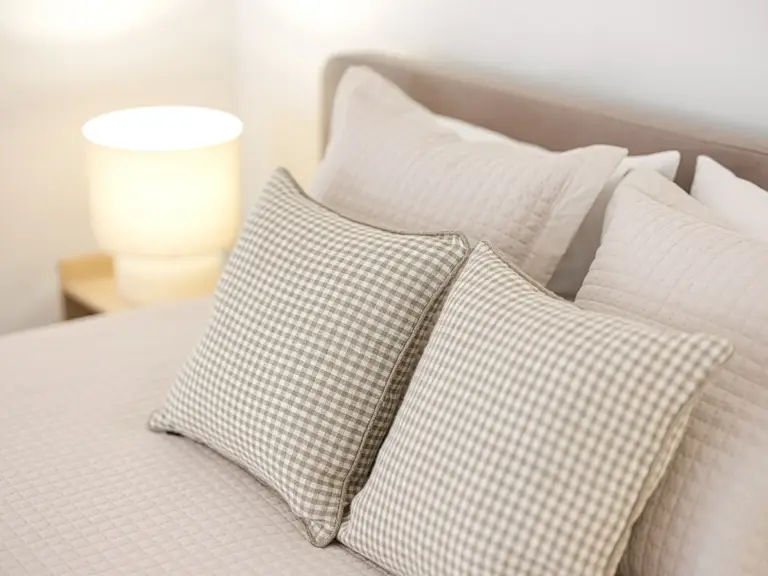 Decorative pillows and bedside lamp in master bedroom of OPAL BLUE TLA apartment