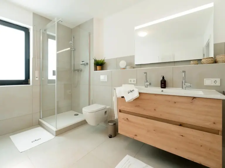 Modern bathroom with walk-in shower and double vanity in Opal White apartment