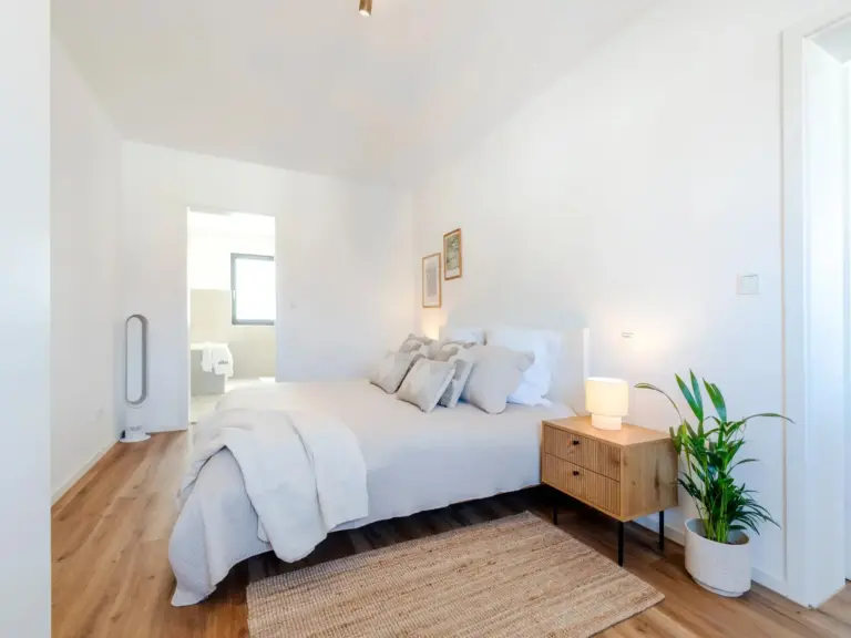 Bright bedroom with king-size bed and warm decor in Opal White apartment
