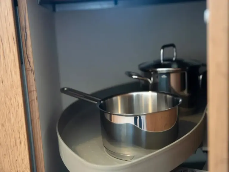 Organized pots and pans stored in a modern kitchen cabinet