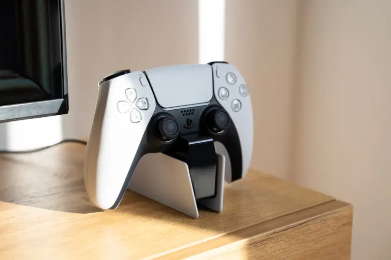 Modern PlayStation 5 gaming controller on a stand in bright Opal White apartment