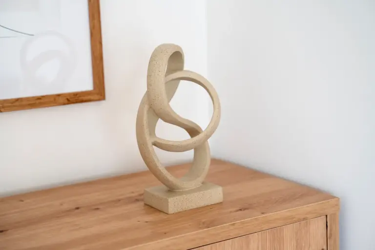 Abstract decorative sculpture on a wooden cabinet in modern Opal White apartment