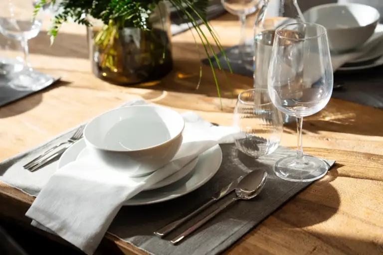 Elegant dining table setting with plates, glasses and natural sunlight