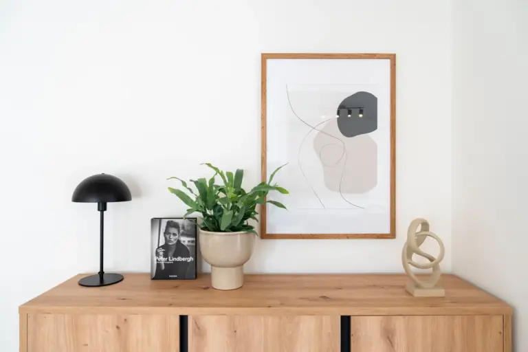 Modern sideboard with plant, lamp, and framed abstract artwork