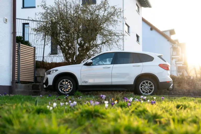 White car parked in front of Stay Eden Opal apartment house with garden