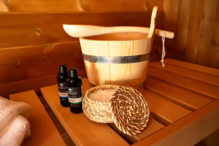 Sauna accessories with wooden bucket, ladle, oils and salt in Opal apartment house
