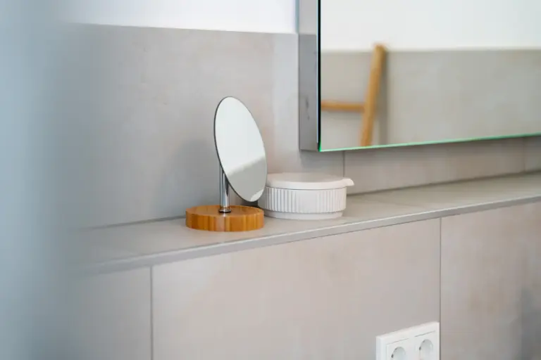 Bathroom detail with small mirror and accessories in Opal White apartment