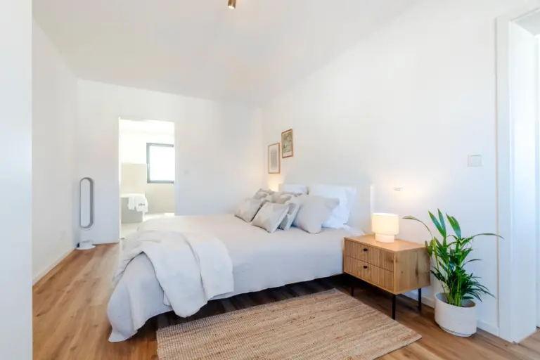 Bright bedroom with king-size bed and warm decor in Opal White apartment
