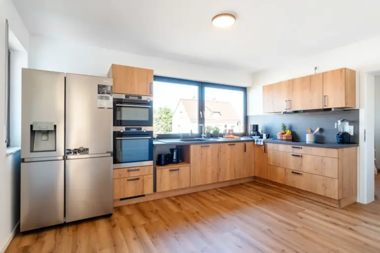 Fully equipped kitchen with side-by-side fridge in Opal White apartment