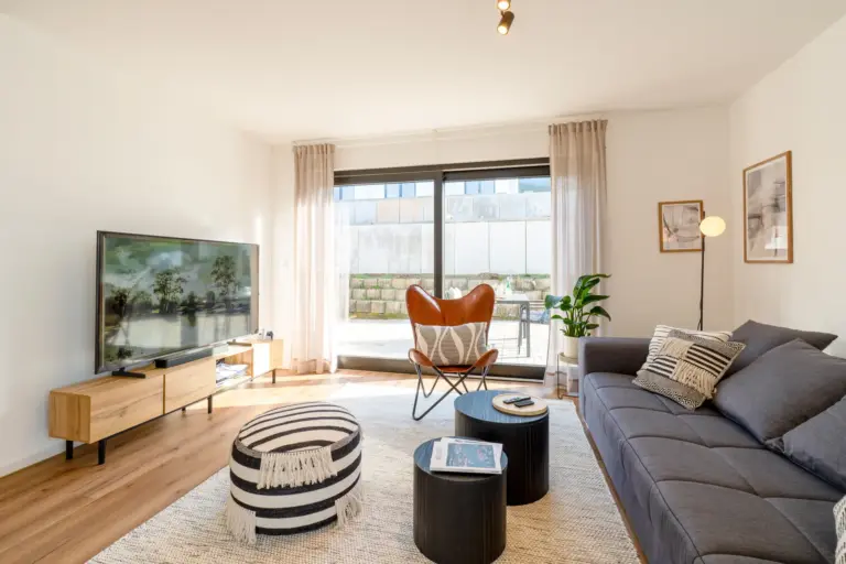 Living room with sofa, 4K Smart TV and terrace access in Opal White apartment