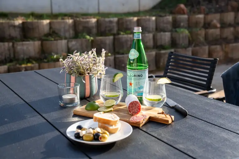 Outdoor terrace table with drinks, snacks, and seating at Opal White apartment