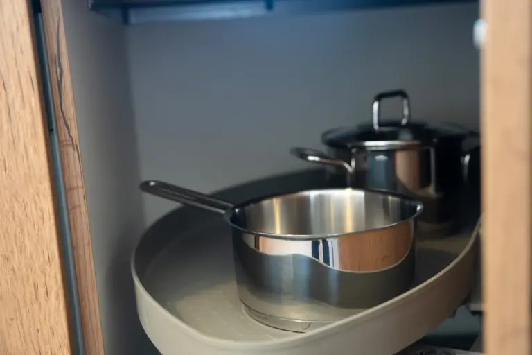 Organized pots and pans stored in a modern kitchen cabinet