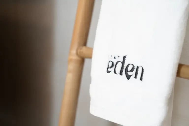 Stay Eden branded towel detail on wooden ladder in modern apartment Opal White
