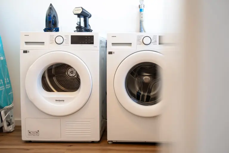 Modern washing machine and dryer in furnished apartment laundry area