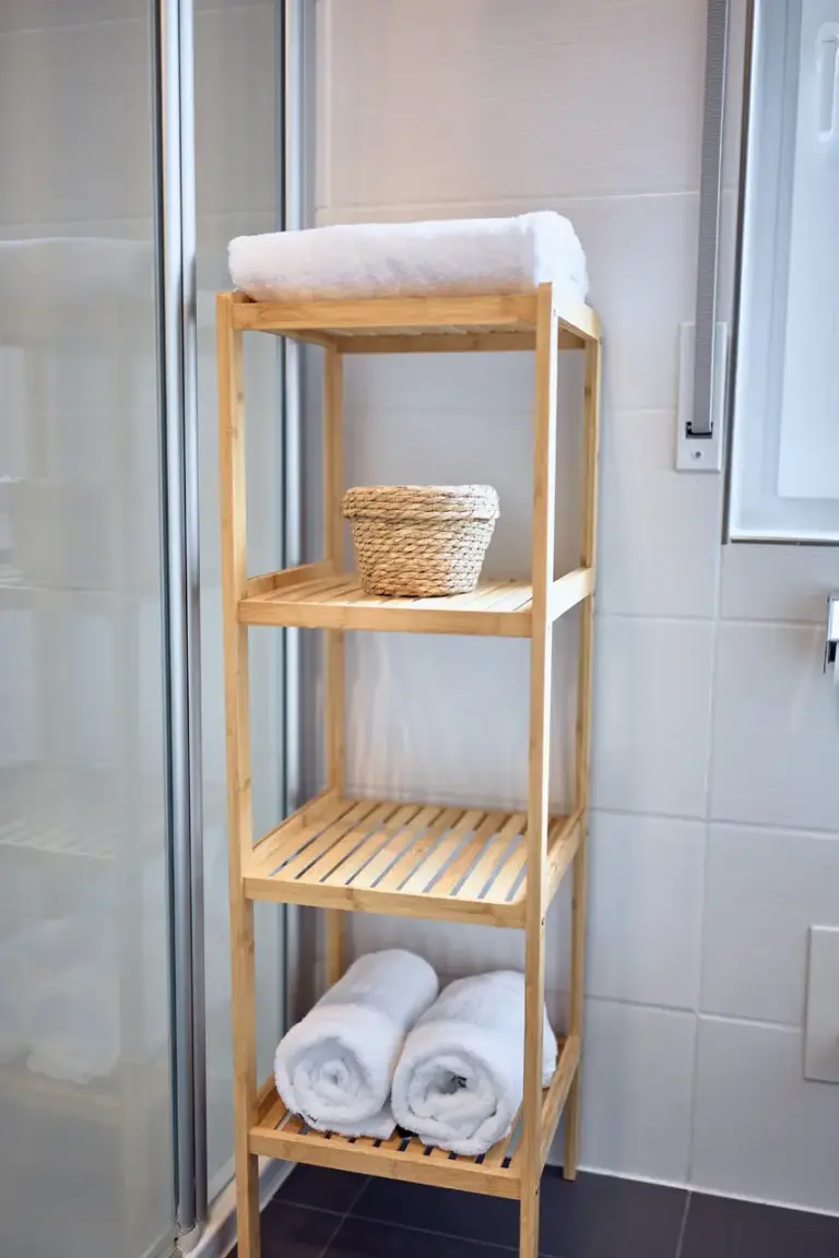 CORAL BLOOM bathroom with wooden shelving and fresh white towels beside the shower