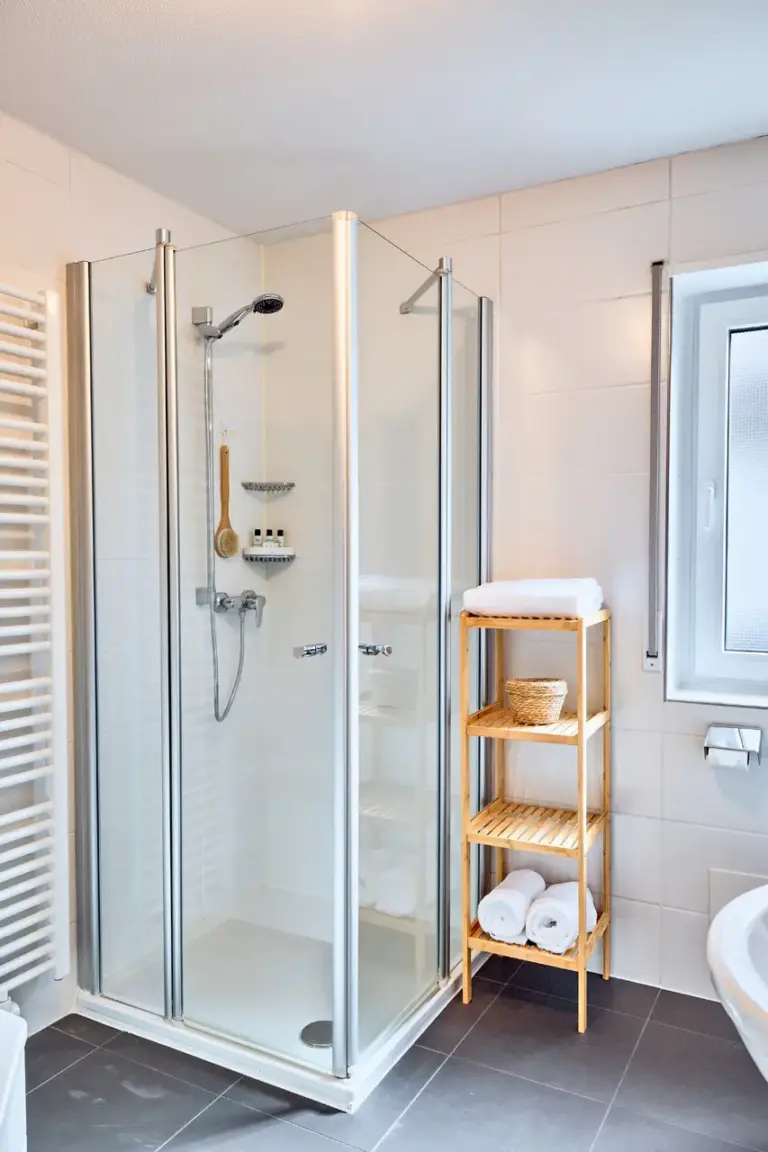 Bright bathroom in CORAL BLOOM with a spacious glass walk-in shower and fresh towels