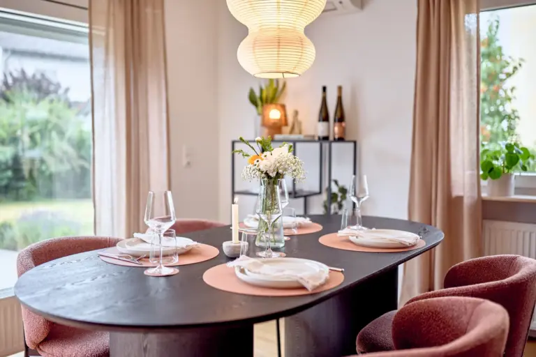 Elegant dining area with a set table, warm lighting and garden views at CORAL BLOOM