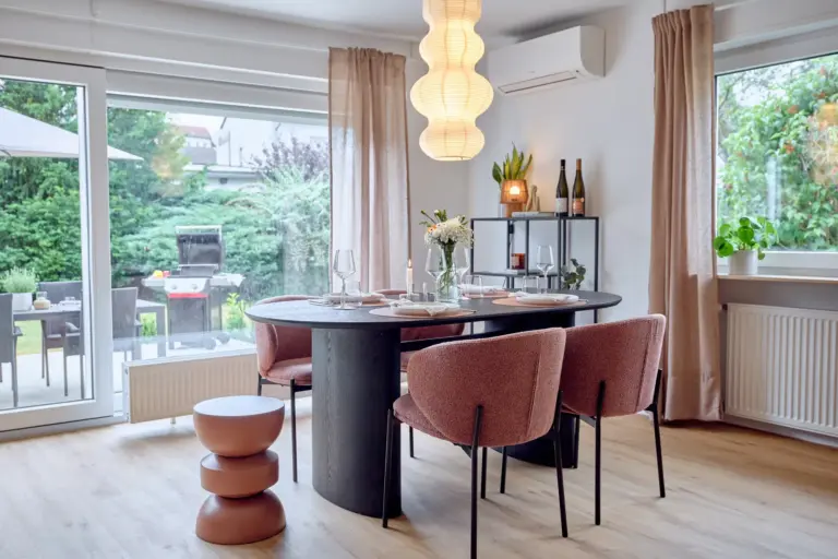 CORAL BLOOM dining area with chairs, set table and direct access to the private terrace and garden