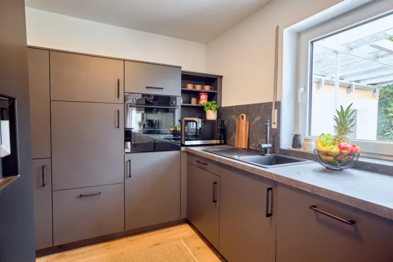 CORAL BLOOM modern kitchen with oven, microwave, sink, dark cabinetry and spacious countertop