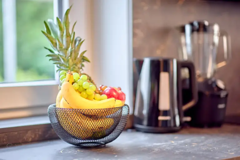 Fresh fruit basket on the kitchen counter at CORAL BLOOM with kettle and blender in the background