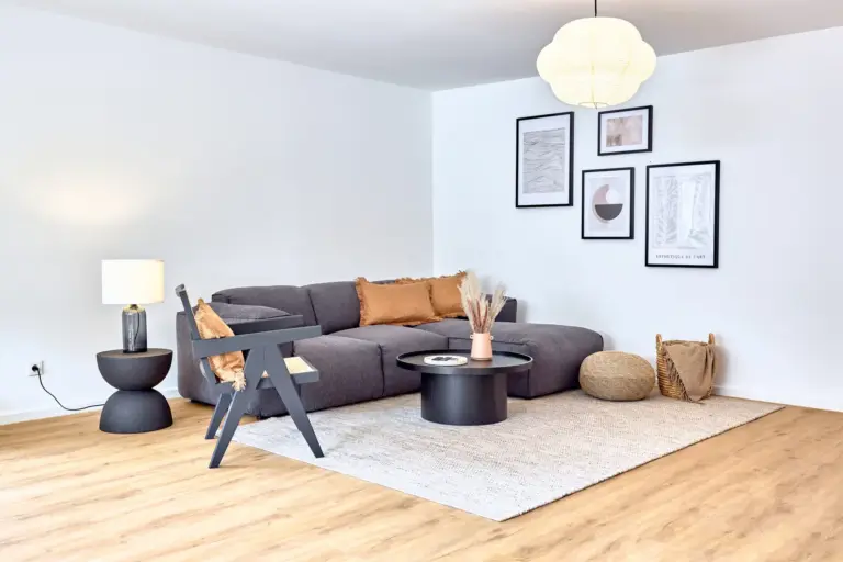 Spacious modern living room at CORAL BLOOM with large sectional sofa and warm natural accents