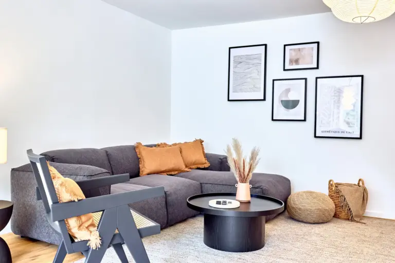 Modern living room with a spacious gray sofa, warm accents and contemporary wall art in CORAL BLOOM