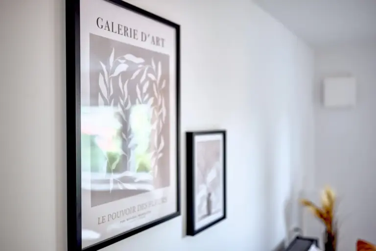 Framed botanical wall art adding a refined decorative touch to CORAL BLOOM's master bedroom