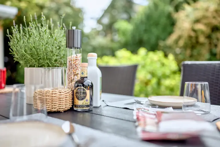Set outdoor dining table with herbs, seasonings and garden views at CORAL BLOOM