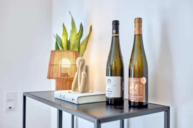 Two wine bottles displayed with warm lighting and decorative accents in CORAL BLOOM