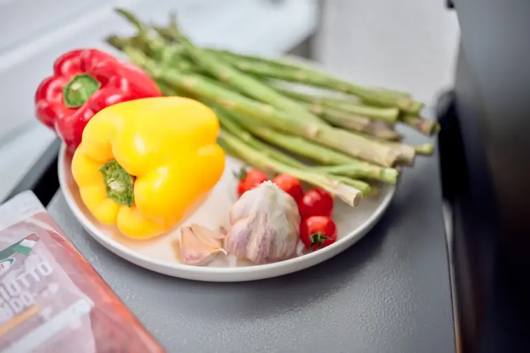 Fresh vegetables including bell peppers, asparagus, tomatoes and garlic in the kitchen at CORAL SUN