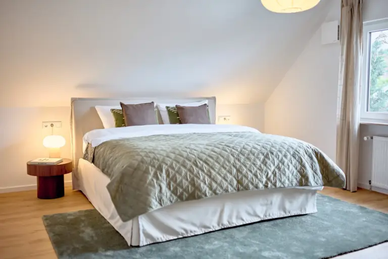 Master bedroom with king-size bed, green textiles and bedside lamps at CORAL SUN