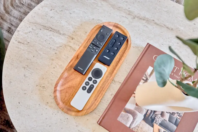 Samsung TV, BOSE soundbar and Apple TV remote controls arranged on a wooden tray on the CORAL SUN coffee table