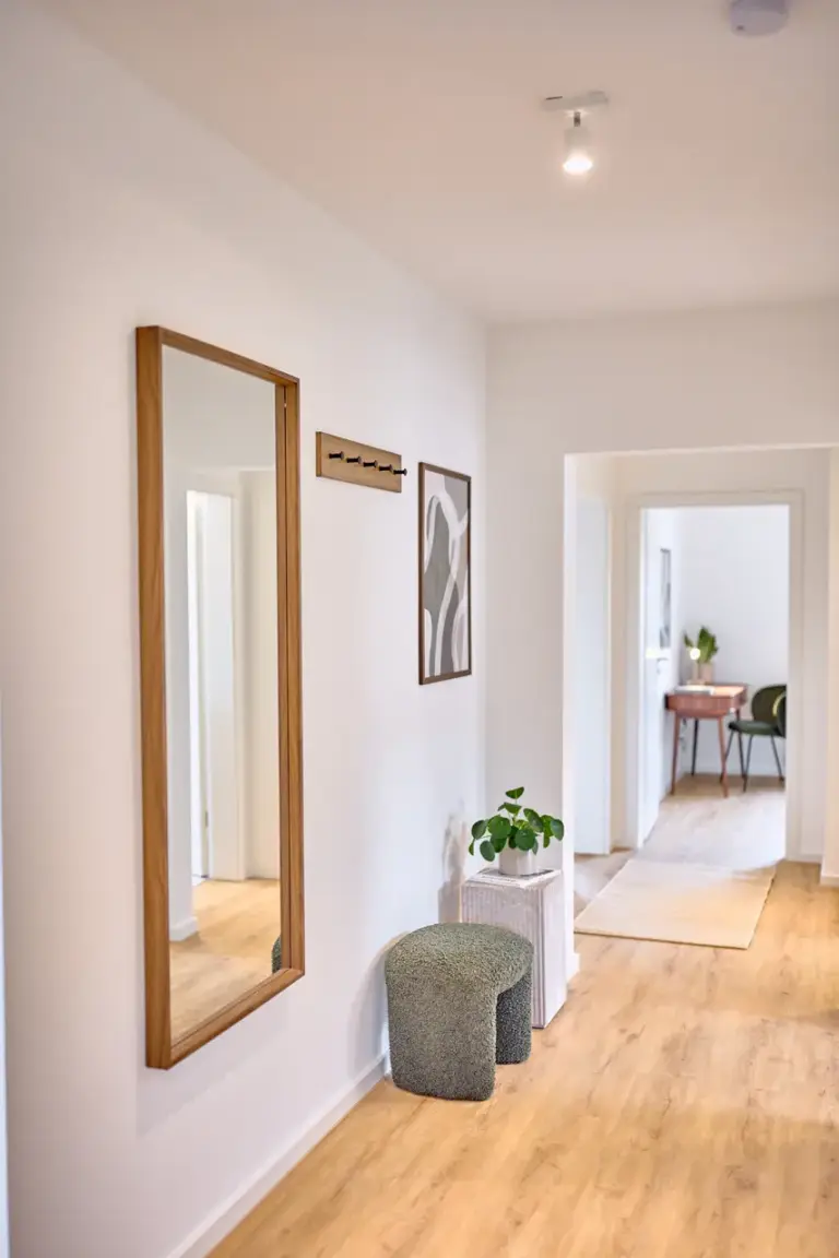 Bright hallway with wooden flooring, full-length mirror and modern decor in CORAL SUN