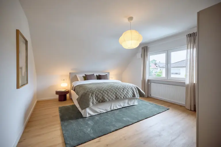 Spacious CORAL SUN master bedroom with king-size bed, green accents and large windows
