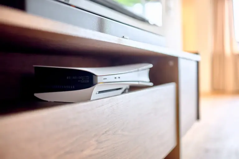 Close-up of the PlayStation 5 console integrated into the entertainment setup in the CORAL SUN living room