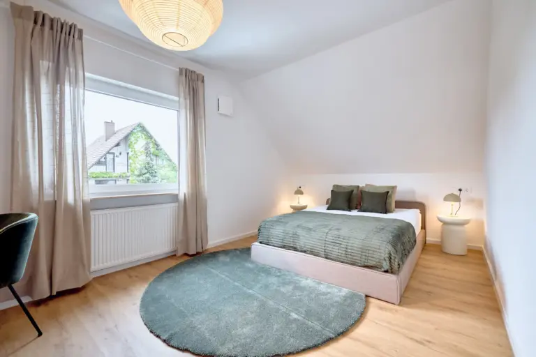Bright CORAL SUN second bedroom with queen-size bed and soft green accents