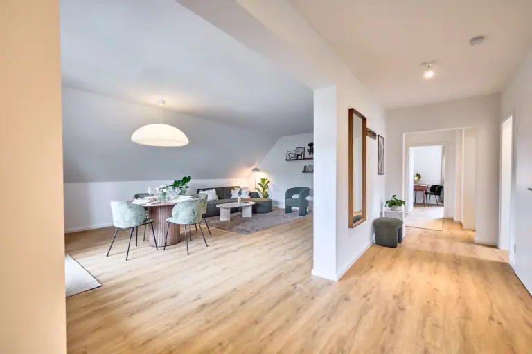 Spacious CORAL SUN interior with open living and dining area, green seating and light wood flooring