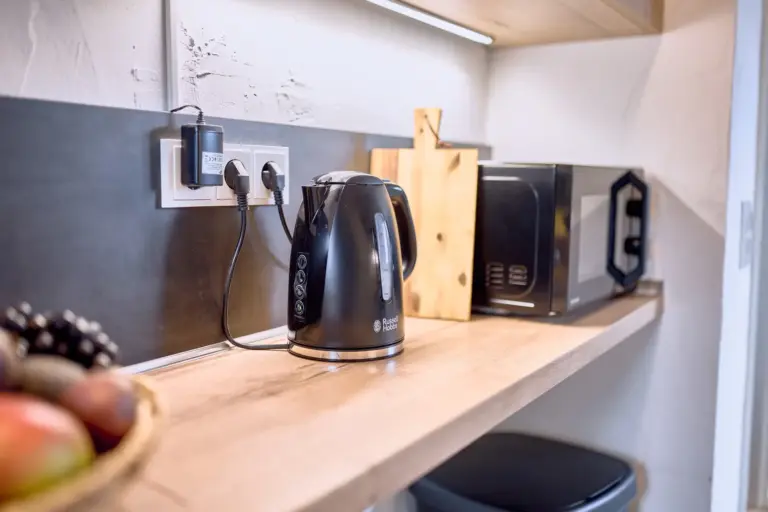 Electric kettle and microwave in kitchen at Stay Eden AMBER GLOW