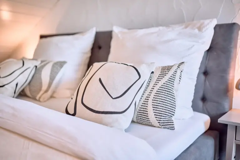 King-size bed with decorative pillows at Stay Eden AMBER GLOW