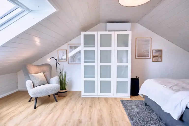 King-size bedroom with wardrobe and reading chair at Stay Eden AMBER GLOW