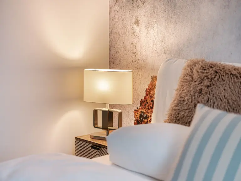 Bedside lamp and king-size bed detail at PEARL SILVER