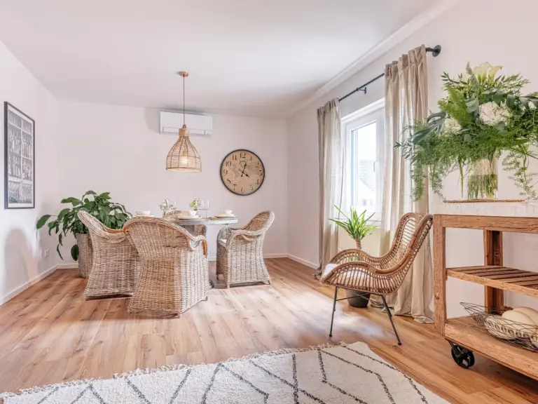 Bright dining area with table and wicker chairs at PEARL WHITE